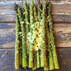- 1 pound fresh asparagus - 4 cloves garlic, minced - 1 medium lemon (zest and juice) - Olive oil - Sea salt and black pepper - Optional: crushed red pepper flakes and grated Parmesan cheese To make Lemon Garlic Roasted Asparagus, you need fresh ingredients. Start with fresh asparagus. Look for spears that are firm and bright green. They should feel crisp to the touch. Next, grab some garlic. Four cloves will give your dish that rich, savory flavor. Finally, you need one lemon. Use it for both zest and juice. This adds brightness and tang to the dish. Now, let’s talk about pantry staples. Olive oil is key for roasting. It helps the asparagus get that lovely golden color. You will also need sea salt and black pepper. These add basic seasoning. If you want a kick, use crushed red pepper flakes. They bring a nice heat. For a touch of richness, sprinkle some grated Parmesan cheese on top. It melts into the asparagus and adds depth. Gather these ingredients together, and you are ready to cook. For the full recipe, check out the provided link. It guides you step by step to create this tasty side dish. - Preheat the oven to 400°F (200°C). This step is key for roasting asparagus. A hot oven helps the asparagus get tender and slightly crispy. - Prepare the marinade in a mixing bowl. In a large bowl, mix together: - 3 tablespoons extra virgin olive oil - 4 cloves garlic, minced - Zest of 1 medium lemon - 2 tablespoons freshly squeezed lemon juice - 1 teaspoon fine sea salt - 1/2 teaspoon freshly ground black pepper - 1/4 teaspoon crushed red pepper flakes (optional for heat) Whisk these ingredients until they blend well. The aroma will be bright and inviting. - Coat the asparagus and arrange on a baking sheet. Add 1 pound of trimmed asparagus to the marinade. Toss gently to coat each spear. This ensures every bite bursts with flavor. Line a baking sheet with parchment paper for easy cleanup. Spread the asparagus in a single layer on the sheet. - Roast for 12-15 minutes, adding cheese towards the end. Place the baking sheet in your preheated oven. Roast until the asparagus is tender yet crisp. About 2 minutes before the end, sprinkle 2 tablespoons of grated Parmesan cheese over the asparagus. This adds a creamy, savory touch. Once done, let the asparagus cool slightly before serving. You can find the full recipe to guide your cooking experience. Enjoy the bright taste of lemon and garlic in a simple yet delightful dish! - Look for firm and vibrant green spears. - Avoid asparagus with soft or wilted tips. When picking asparagus, freshness is key. I always choose spears that feel crisp and look bright. This choice ensures a better flavor and texture after roasting. If you find asparagus with yellowing or limp tips, skip them. They won't taste good and can ruin your dish. - Try adding herbs like thyme or basil for extra depth. - Serve on a platter with lemon wedges for a pop of color. To boost flavor, consider mixing in fresh herbs. Thyme adds a lovely earthiness. Basil brings a sweet touch that pairs well with lemon. For an elegant touch, place the roasted asparagus on a large platter. Adding lemon wedges beside the dish allows guests to squeeze more juice. This little detail makes your meal more interactive and visually appealing. {{image_4}} You can easily change this dish to meet your needs. For those who follow a vegan diet, try using nutritional yeast instead of cheese. This gives a cheesy flavor without dairy. If you're watching your sodium intake, swap out sea salt for herbs. Try garlic powder or onion powder for extra taste without the salt. Mix things up by using different veggies. Broccoli or green beans work well with lemon and garlic. They soak up flavors and add variety to your meals. You can also try herbs like thyme or rosemary. These herbs pair nicely with asparagus and add a fresh twist. Experimenting with spices like cumin or smoked paprika can create a fun new flavor profile for your dish. To keep your Lemon Garlic Roasted Asparagus fresh, use an airtight container. Glass or plastic containers with tight lids work well. Store the asparagus in the fridge. It will stay good for about 3 to 5 days. If you want the best taste, eat it sooner rather than later. To reheat, the oven is your best friend. Preheat it to 350°F (175°C). Place the asparagus on a baking sheet and warm for about 10 minutes. This method keeps the texture nice and crisp. If you're in a hurry, you can use a microwave. Heat it in short bursts of 30 seconds. Be careful not to overcook it, or it may become mushy. Roasting asparagus takes about 12 to 15 minutes. You want them tender but still crisp. Check them at the 12-minute mark. If they are bright green and tender, they are ready! You can use frozen asparagus, but the texture will differ. Frozen asparagus often becomes softer when cooked. For the best taste, fresh asparagus is the way to go. Lemon garlic roasted asparagus pairs well with many dishes. Consider serving it with grilled chicken, salmon, or steak. It also goes great with quinoa or rice. For a complete meal, add a fresh salad. The ingredients in this recipe are already gluten-free. Use gluten-free cheese or skip the cheese if needed. Enjoy the flavors without worry! For the full recipe, check out the link provided. In this post, we looked at how to make Lemon Garlic Roasted Asparagus. We covered key fresh ingredients and pantry staples you need to create this dish. I provided step-by-step instructions for roasting, along with tips for selecting and storing asparagus. We also discussed variations to fit dietary needs and answered FAQs about roasting times and serving suggestions. Cooking this simple dish is easy and rewarding. Enjoy your tasty asparagus as a side or a snack!